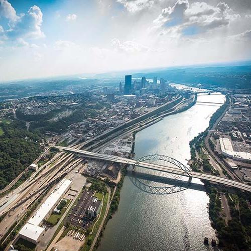 A photo of Pittsburgh in the background with images of CMU students and faculty in the foreground.